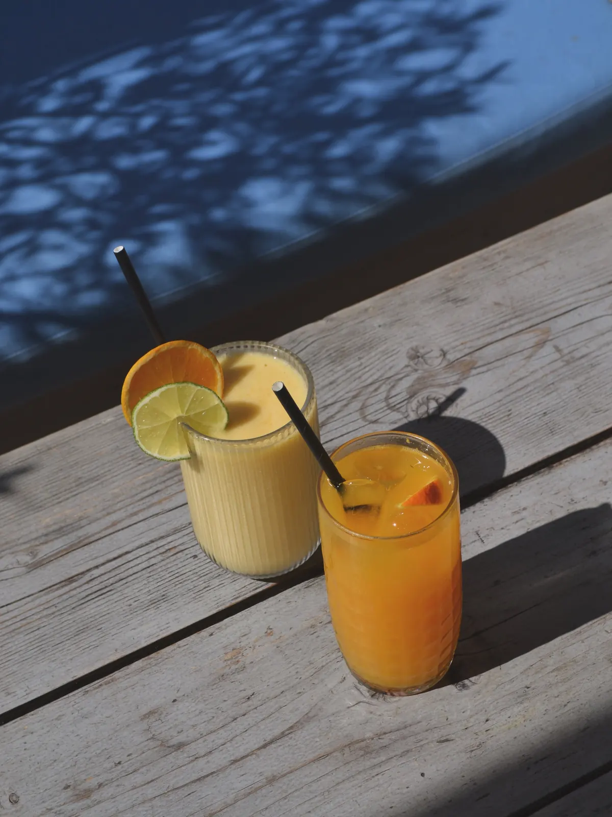 Two fresh juices in dappled sunlight