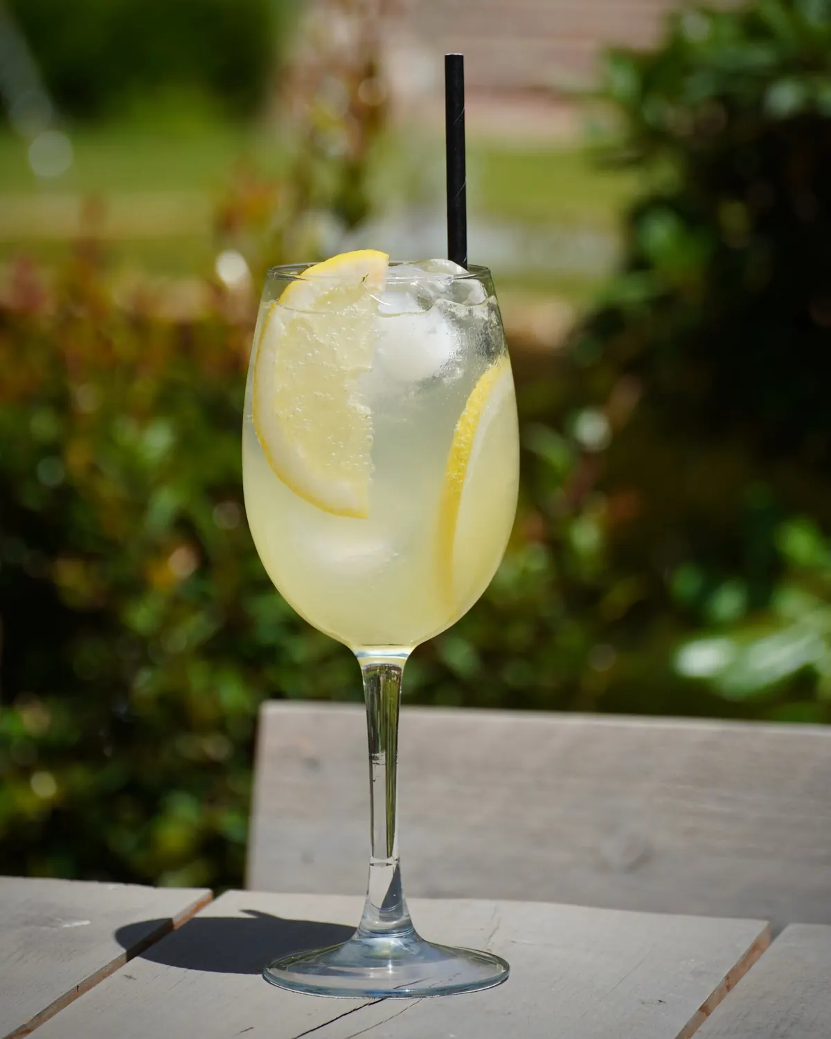 A limoncello spritz with fresh lemon in the garden