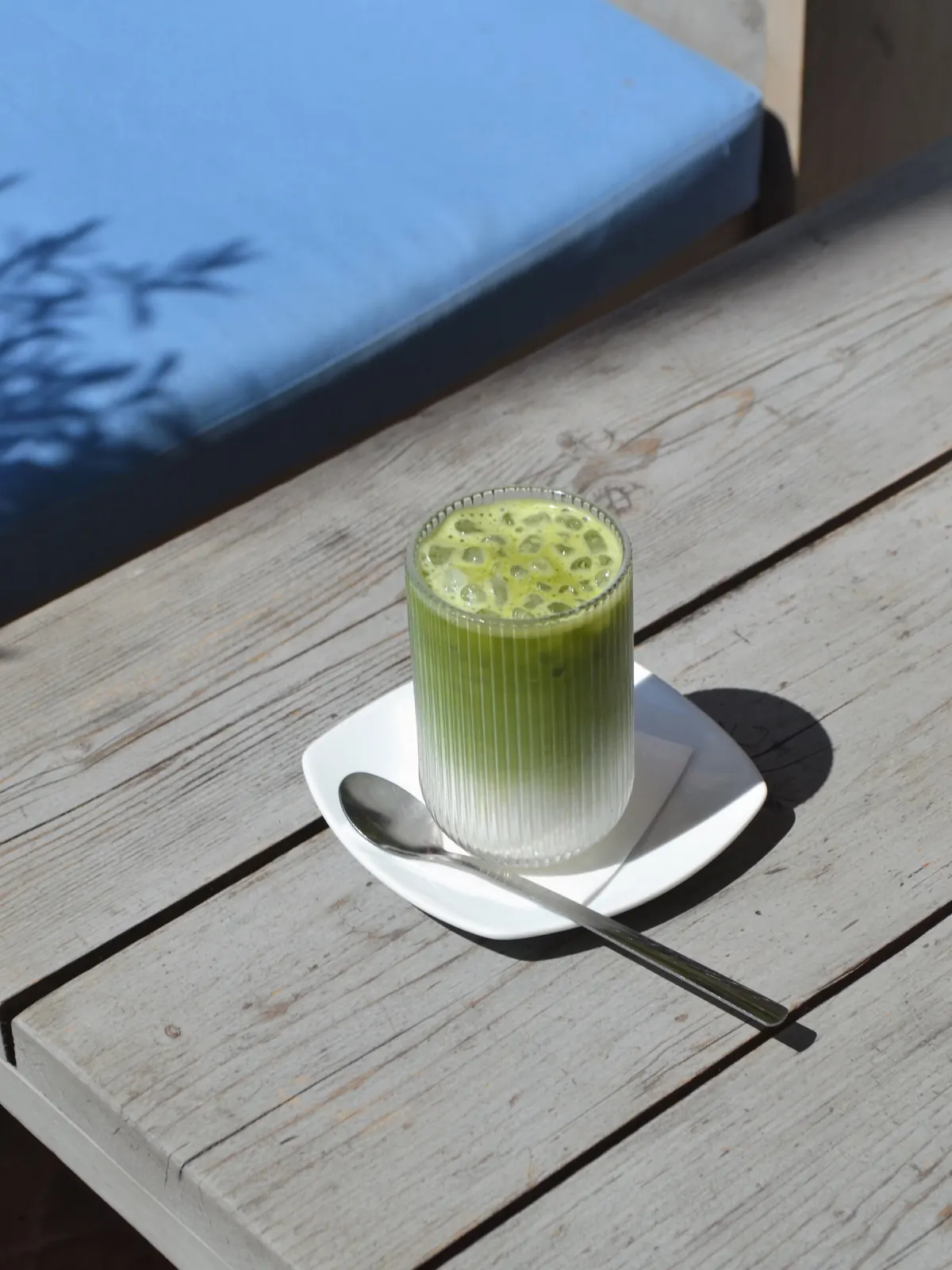 An iced matcha latte on a wooden table