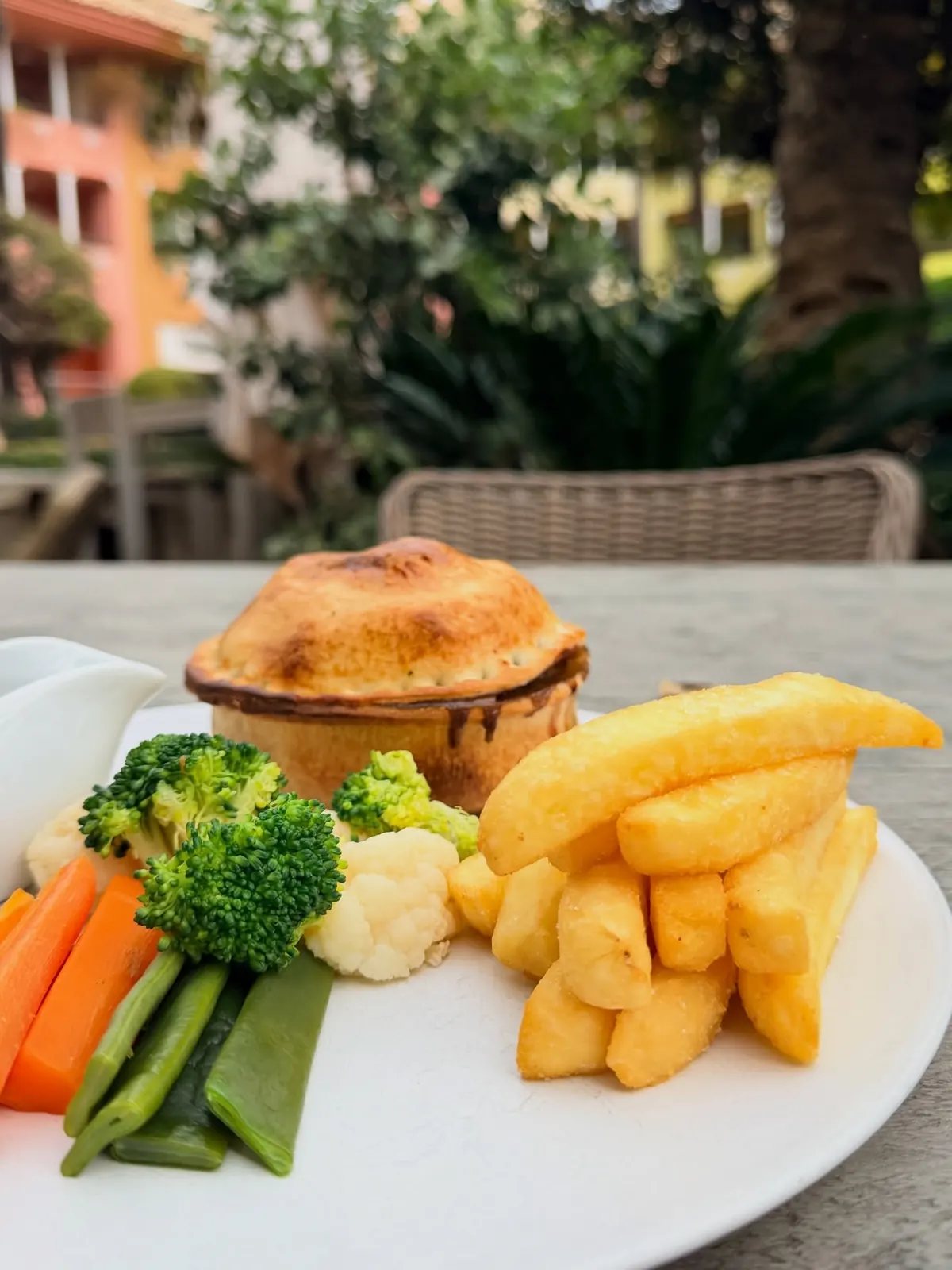 A homemade shortcrust pie with chips and vegetables