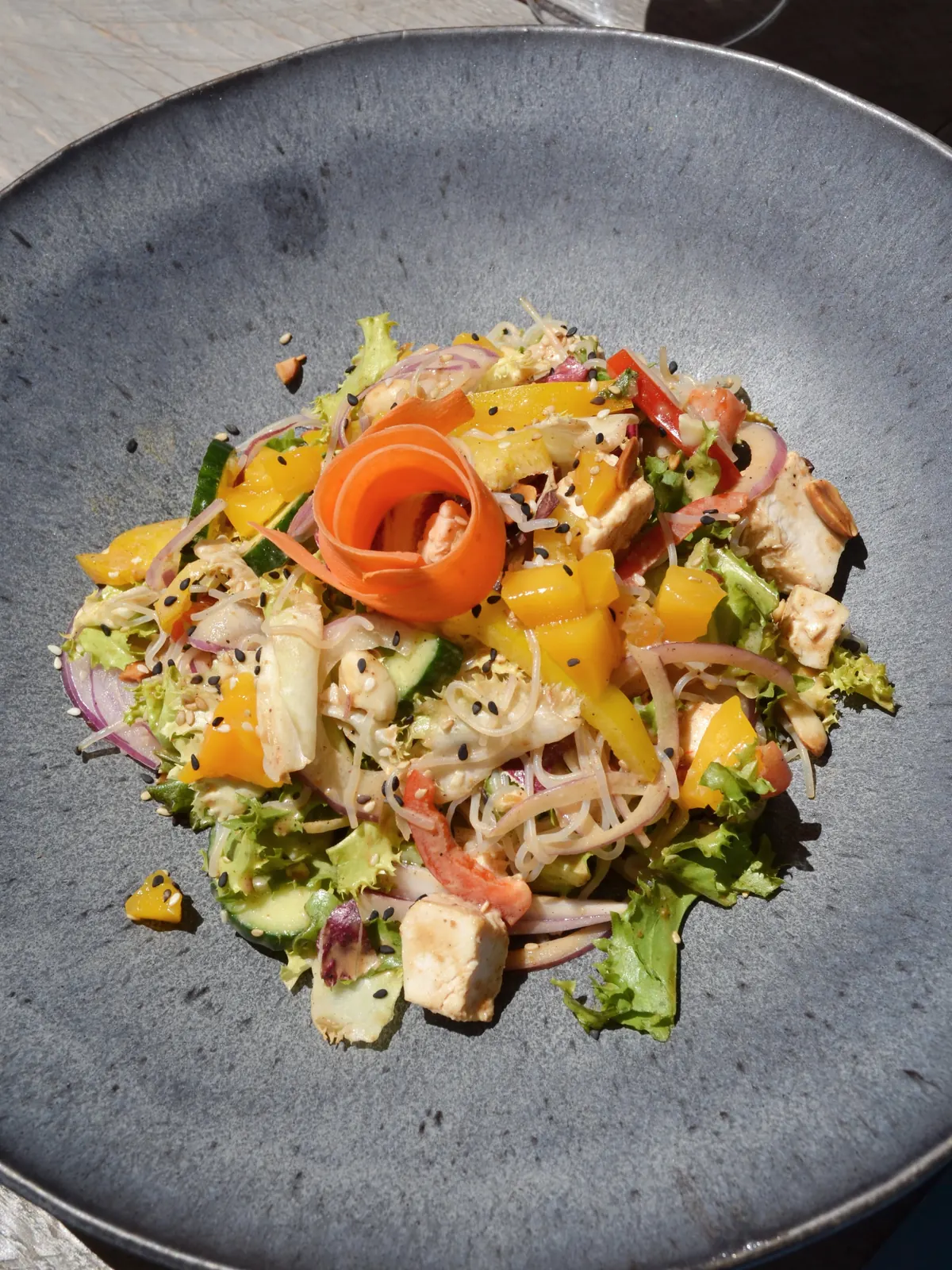 An Asian salad with noodles and mango, seen from above