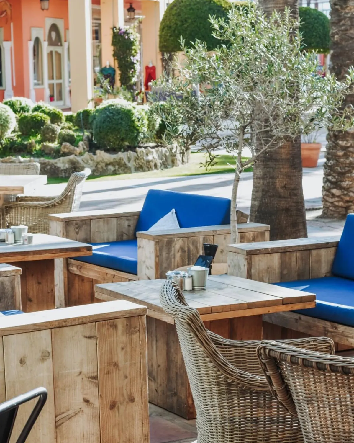 Terrace seating with blue cushions beside the garden